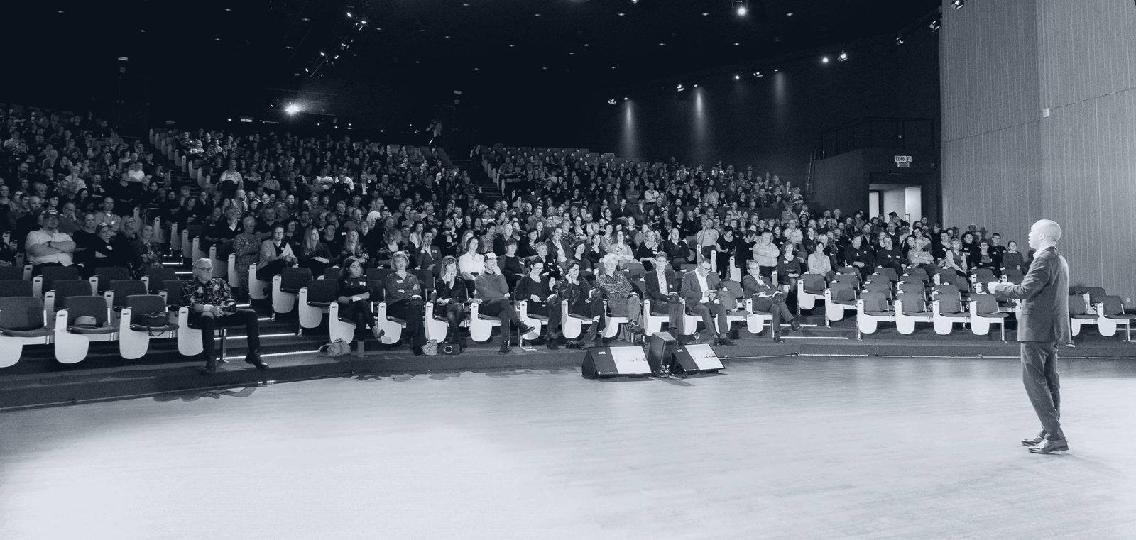 Rachid Et-Taïbi on stage in front of a packed auditorium